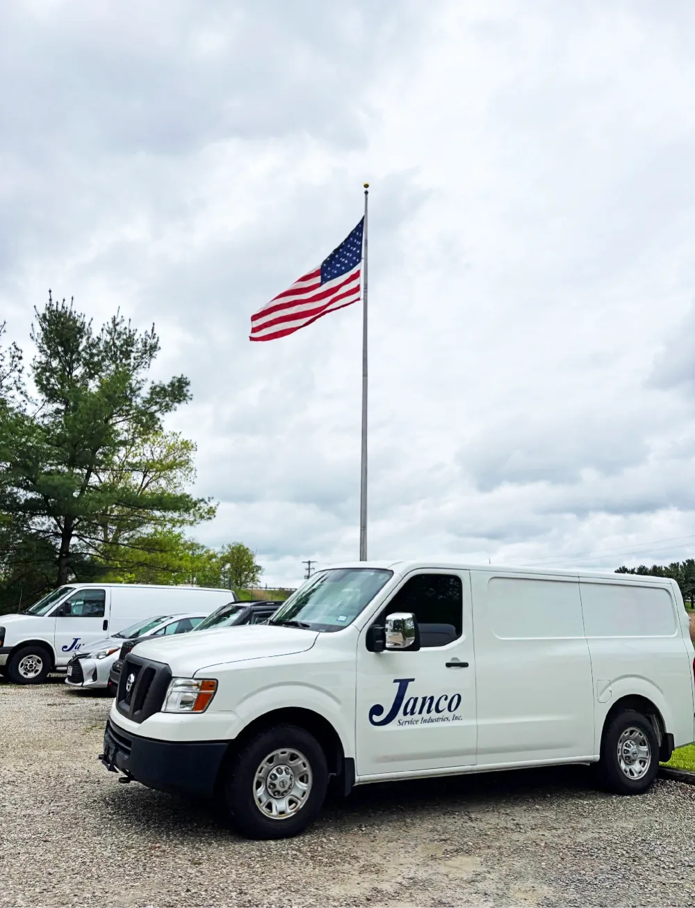 A white Janco van parked under an American flag