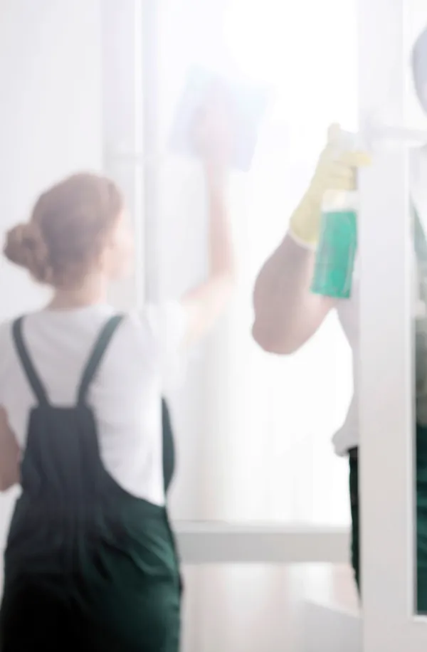 Woman cleaning windows in an office
